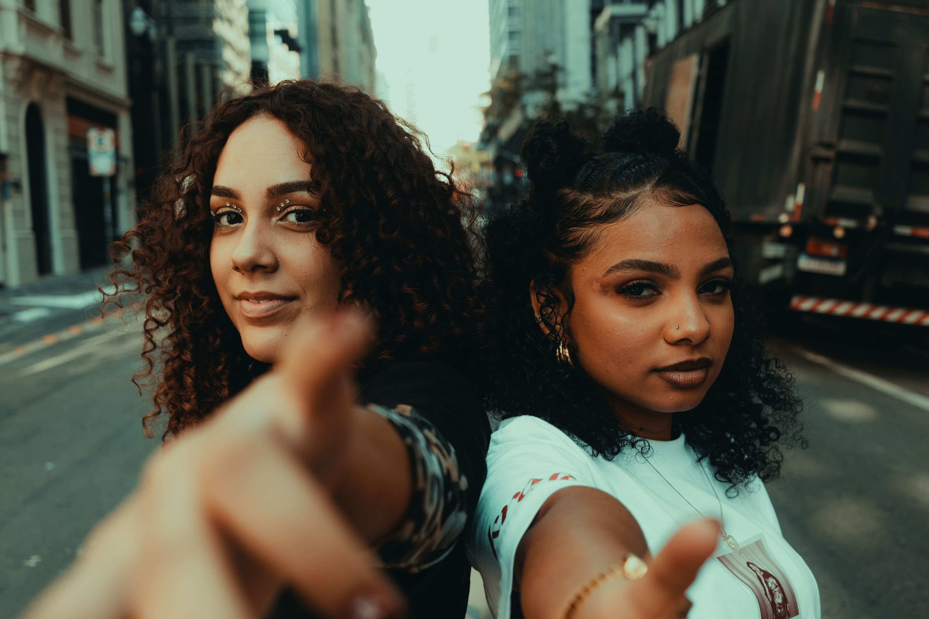 Dos mujeres afrolatinas jóvenes mirando a la cámara en una calle