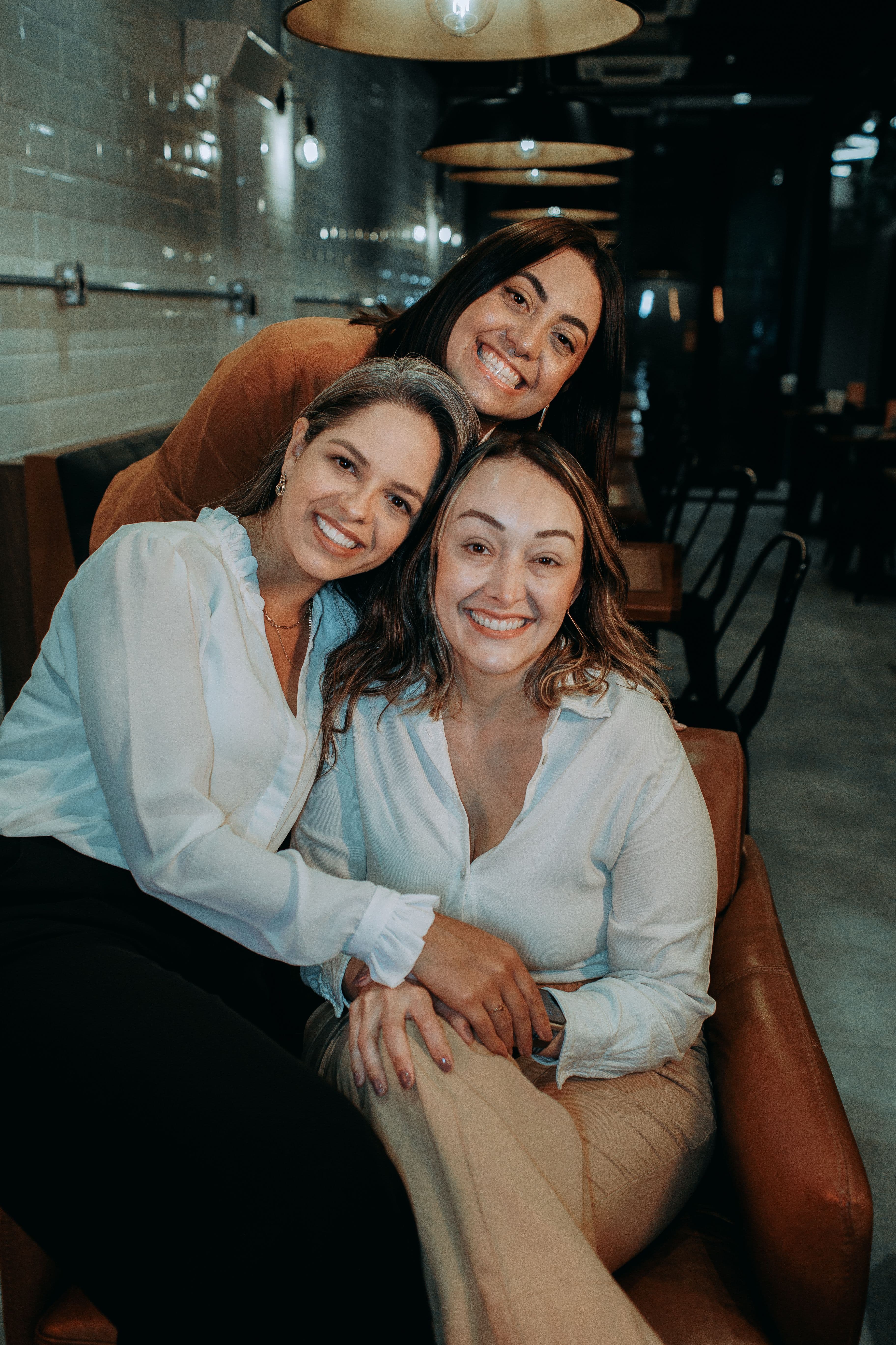 Three Latina women talking in a community space