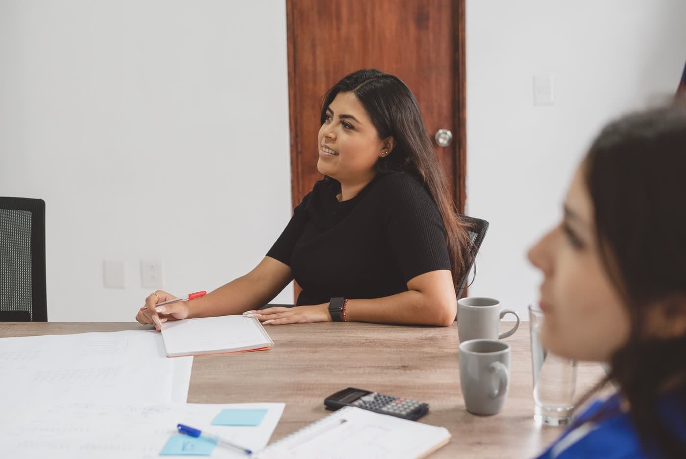 Latina entrepreneur taking notes during a working session